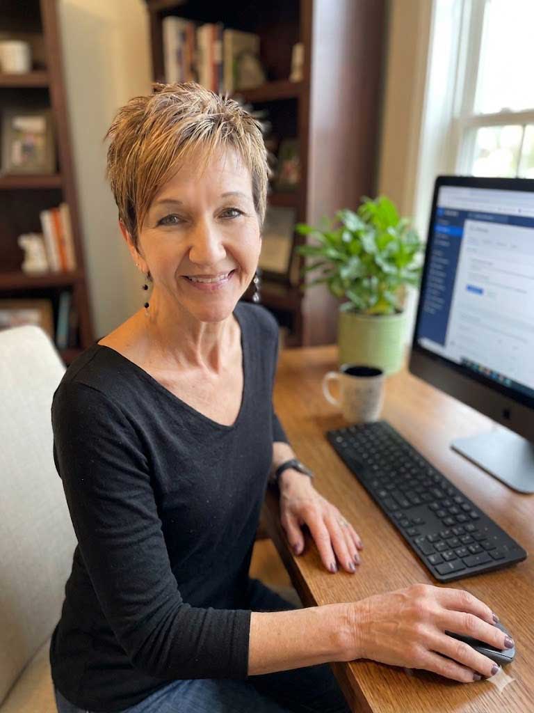 Picture of web developer Sally Sutton sitting at a desk in front of a computer